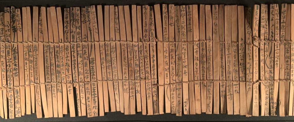Slips of bamboo with Chinese calligraphy written on them.